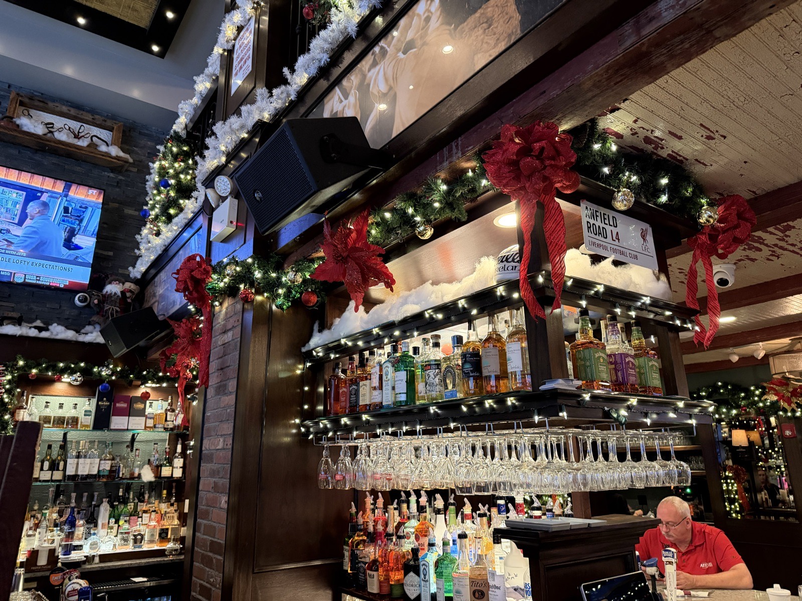 Restaurant bar decorated with garland, lights and oversized red bows