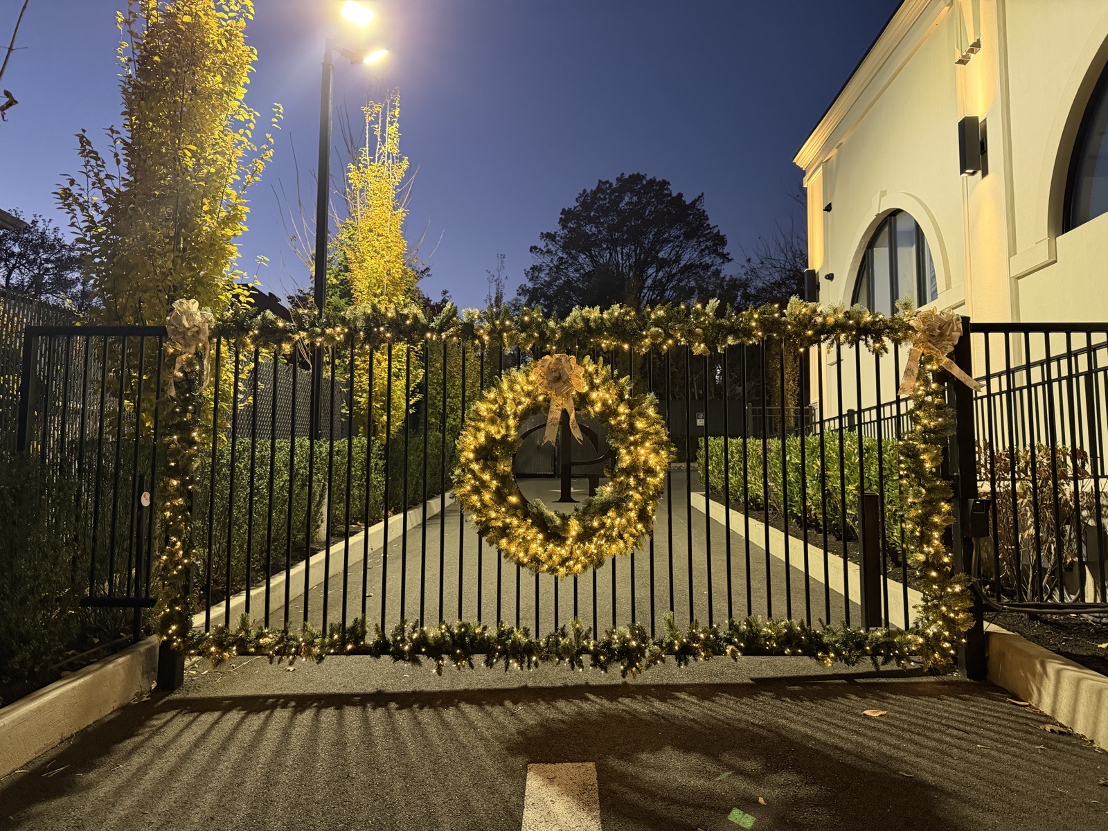 Iron gate with a large lit wreath and garland