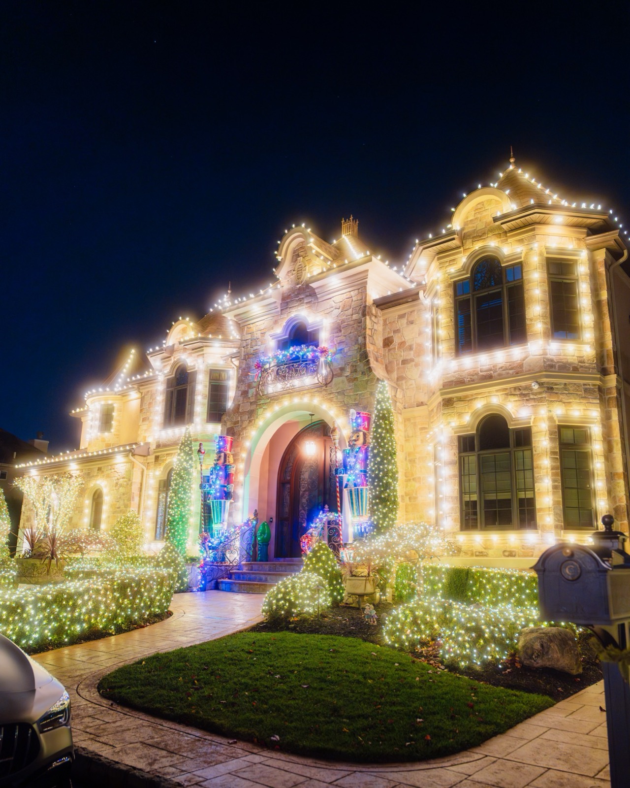 The finished display at night: the stone mansion glowing with warm-white lights