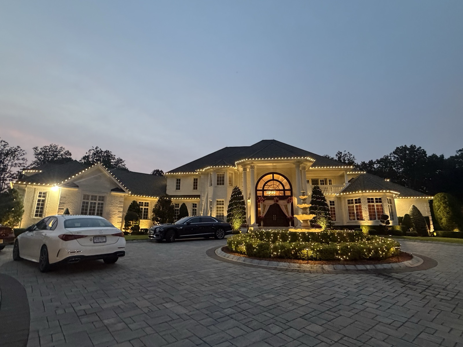 Estate with a circular drive lit at dusk