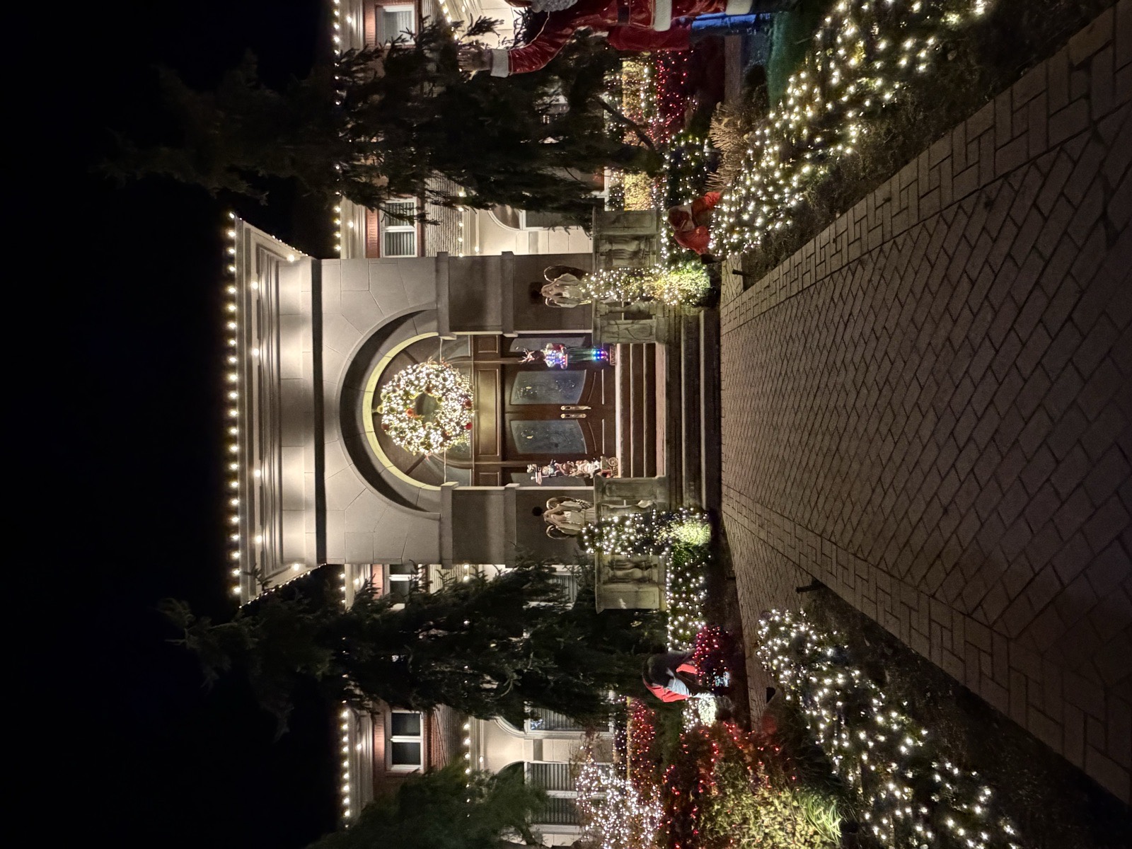 Lit walkway leading to a decorated front entry