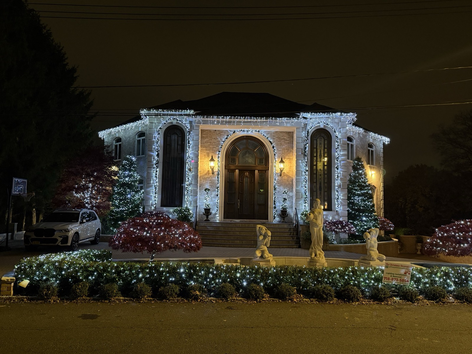White columned home with lit windows and entry